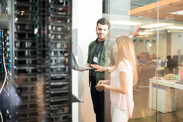 Colleagues discussing in office server room Colleagues discussing in office server room